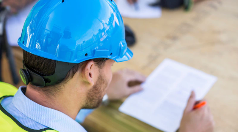 Man in hard hat looking at construction plans