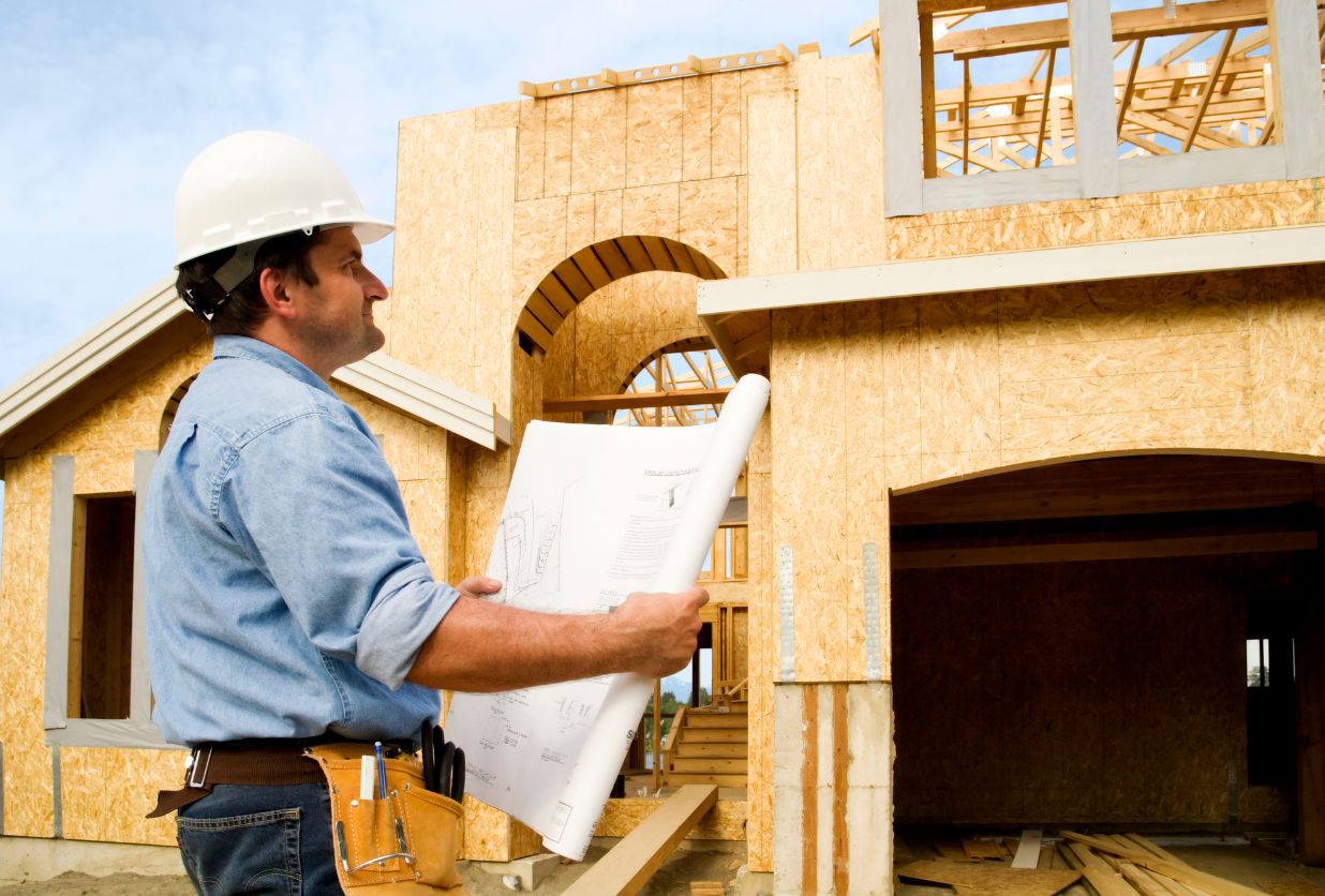 a man in hard hat looking at construction plans